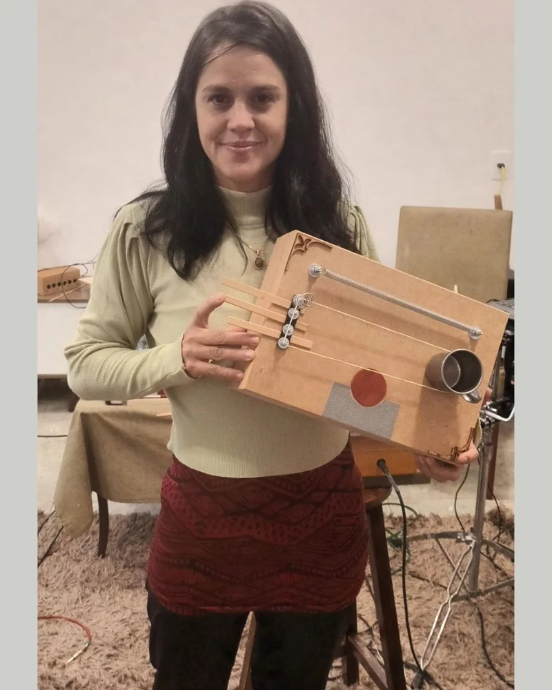 Caroline segurando a noisebox que construiu